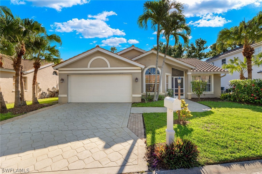 a front view of a house with a yard and potted plants