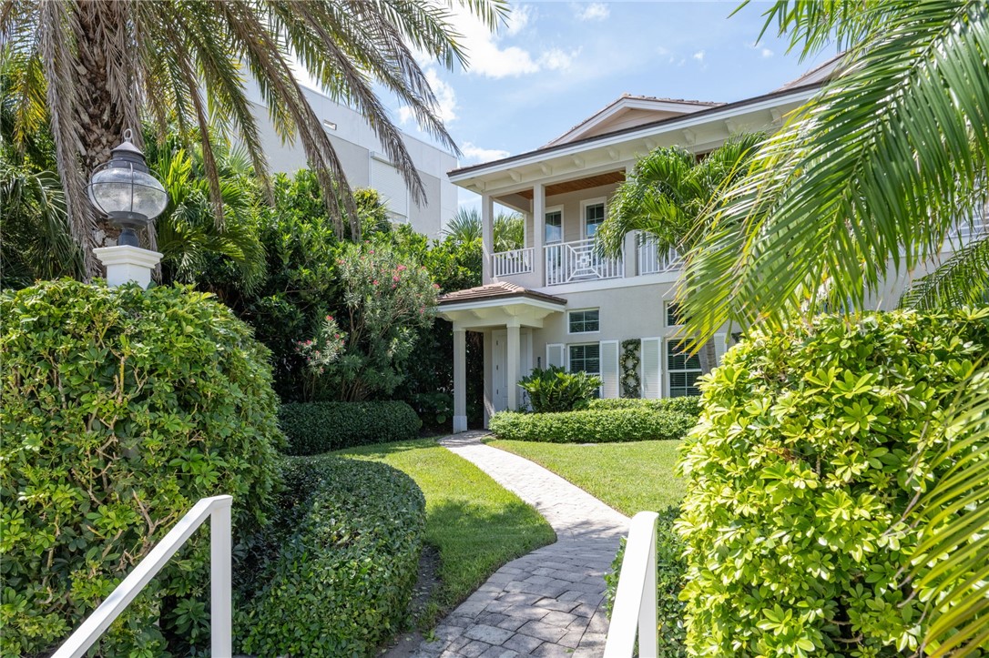 a front view of a house with a yard and potted plants