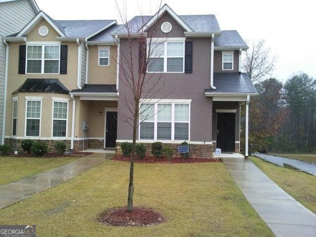 a front view of a house with a garden