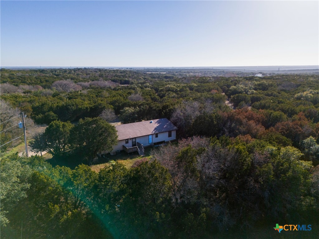 an aerial view of house with yard and mountain view in back