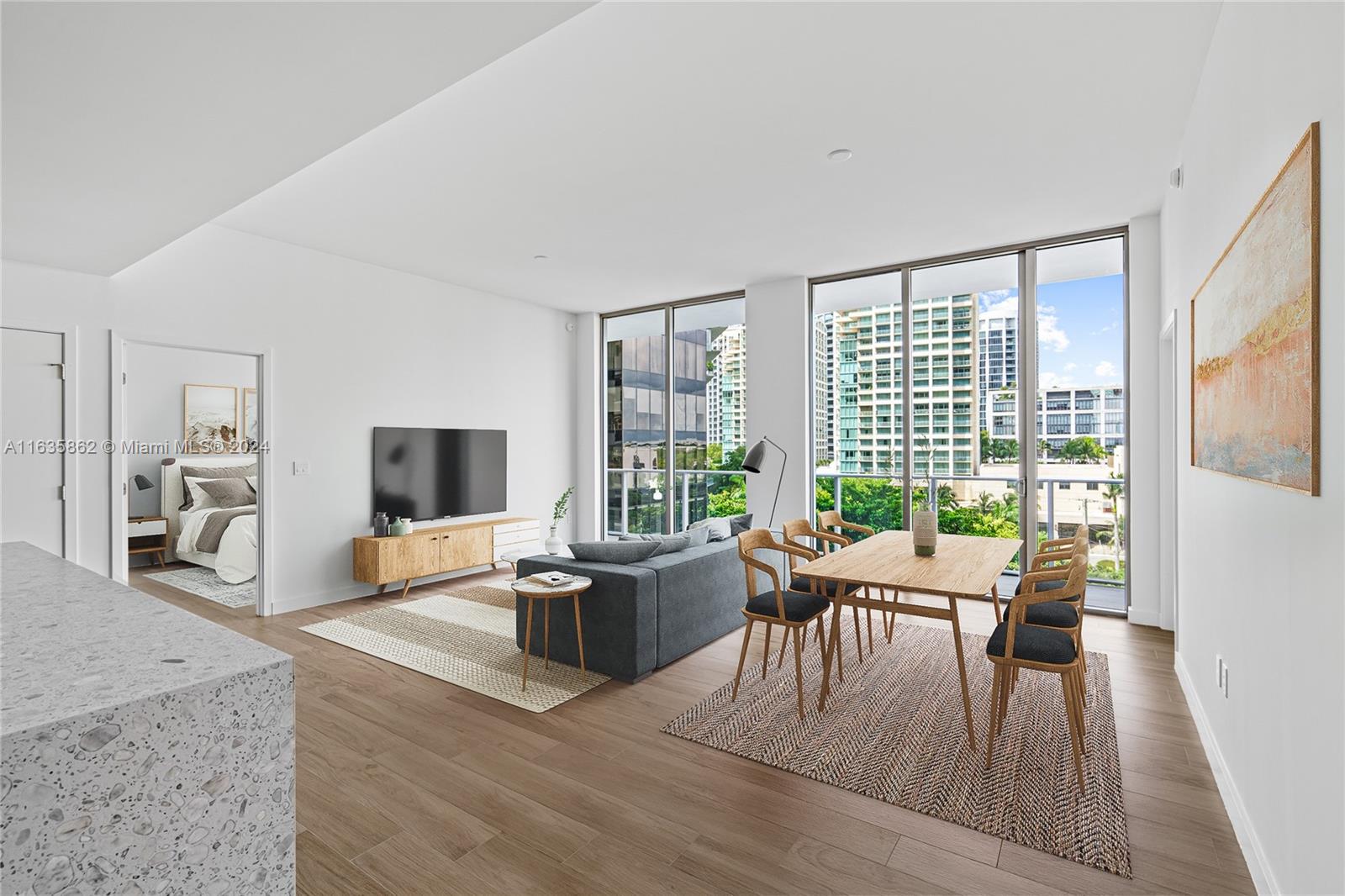 a living room with furniture large windows and wooden floor