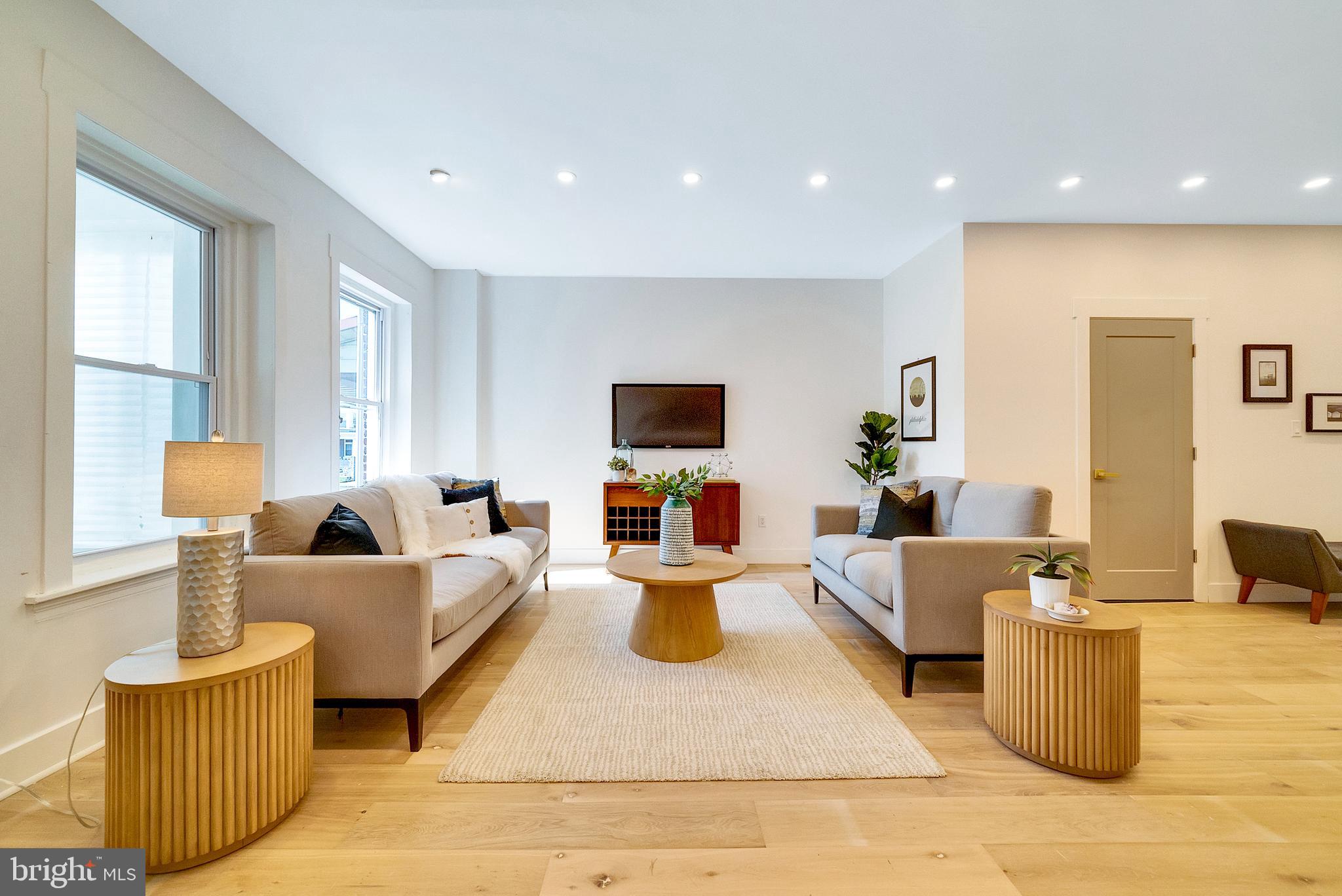 a living room with furniture kitchen view and a window