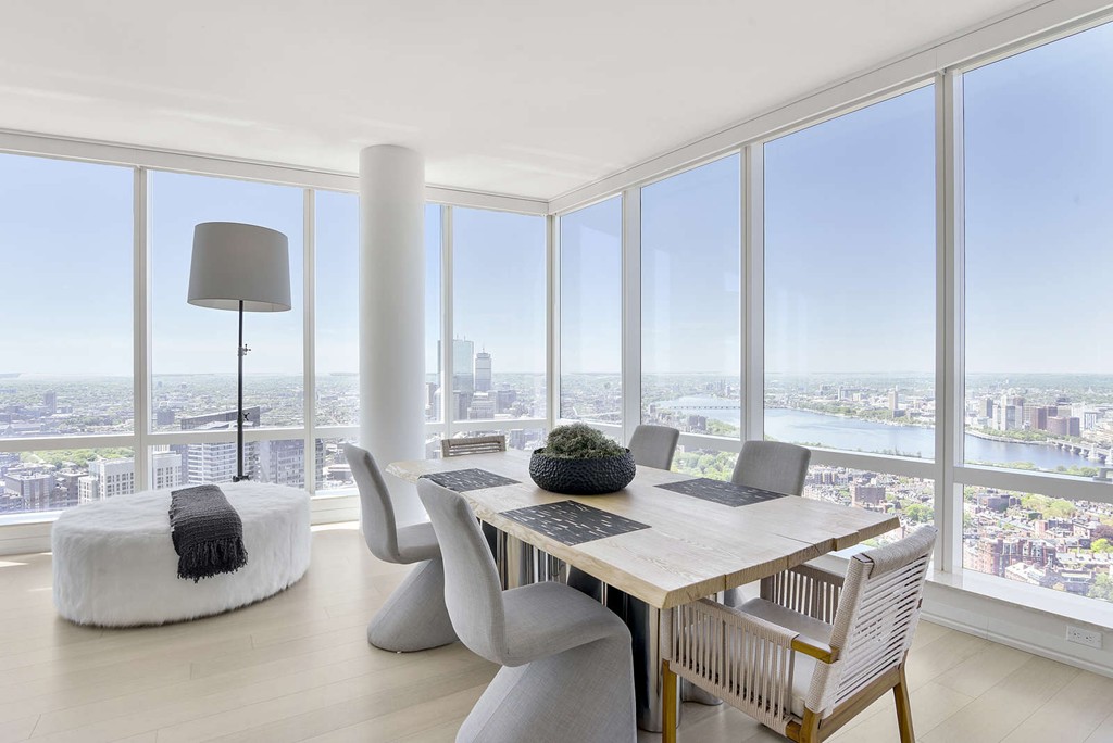 a view of a dining room with furniture and floor to ceiling windows