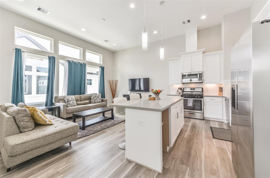 a kitchen with stainless steel appliances kitchen island granite countertop a stove and a refrigerator