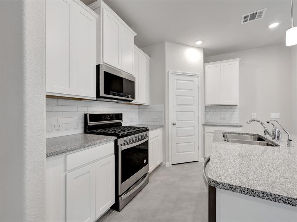 a kitchen with a sink stove and microwave