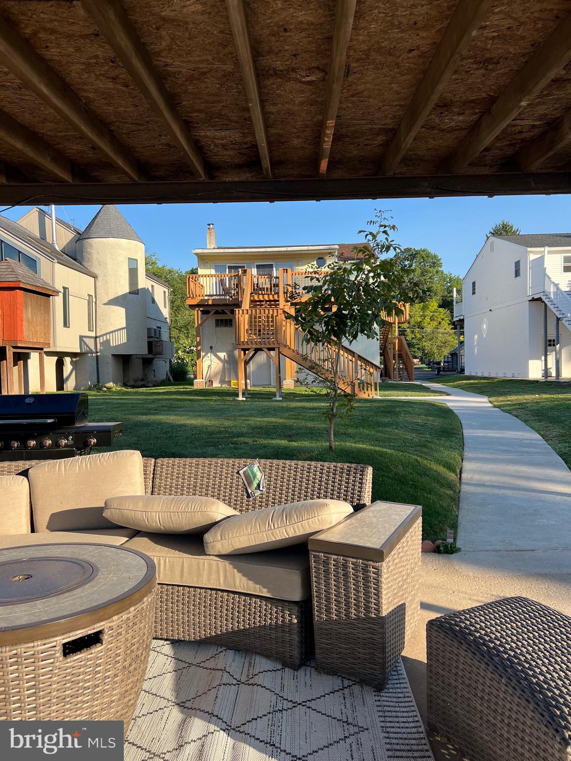 a view of a patio with couches table and chairs and potted plants