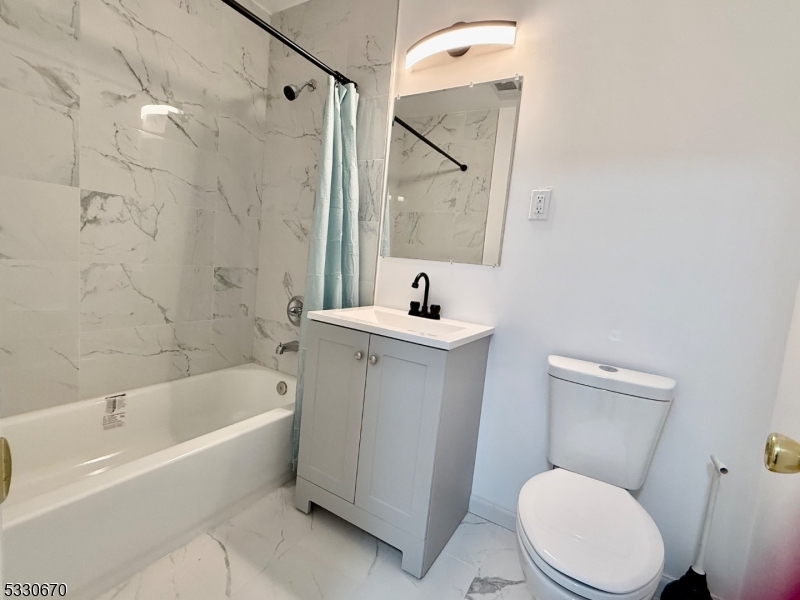 a bath room with a toilet a sink and a bath tub