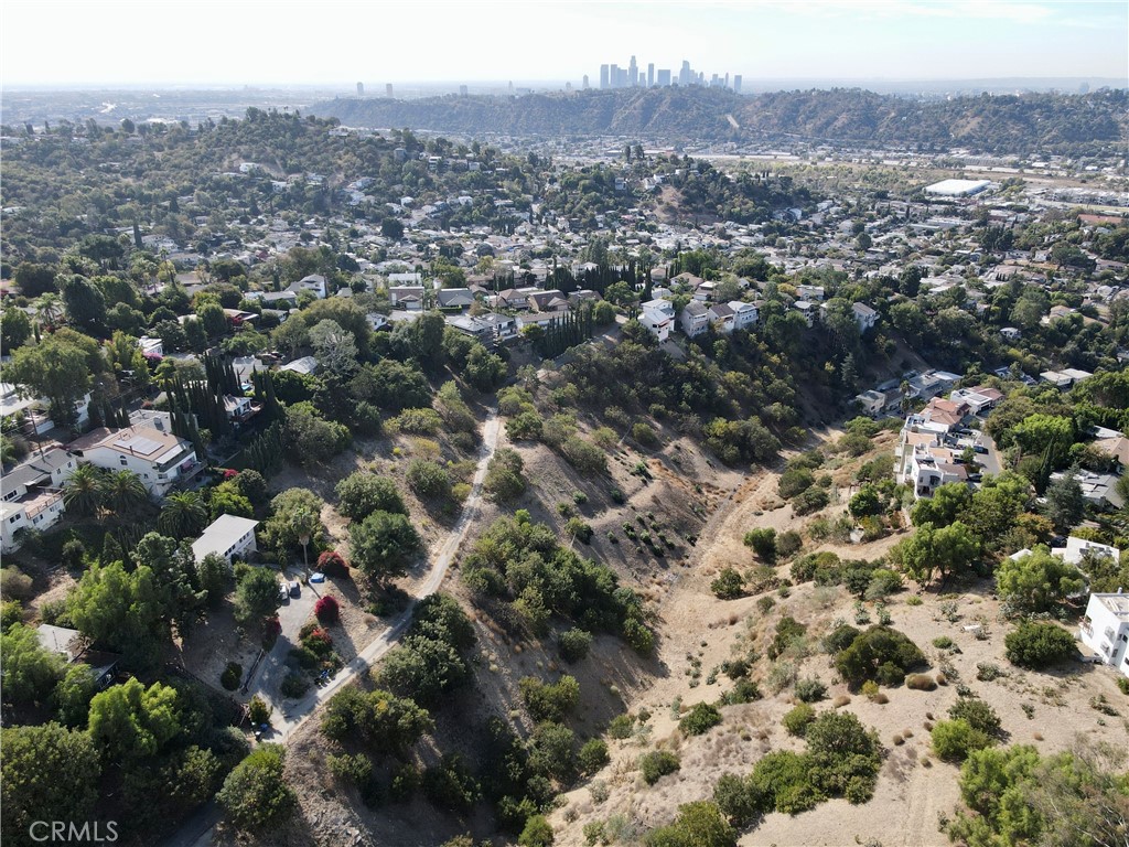 an aerial view of residential houses with outdoor space and trees