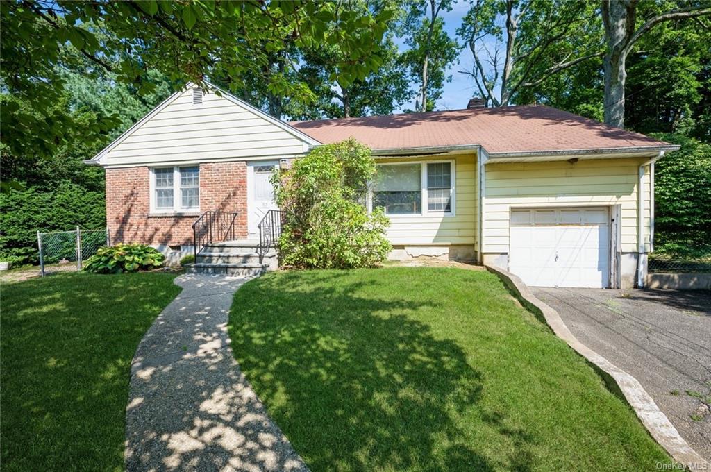 a front view of a house with a yard and trees