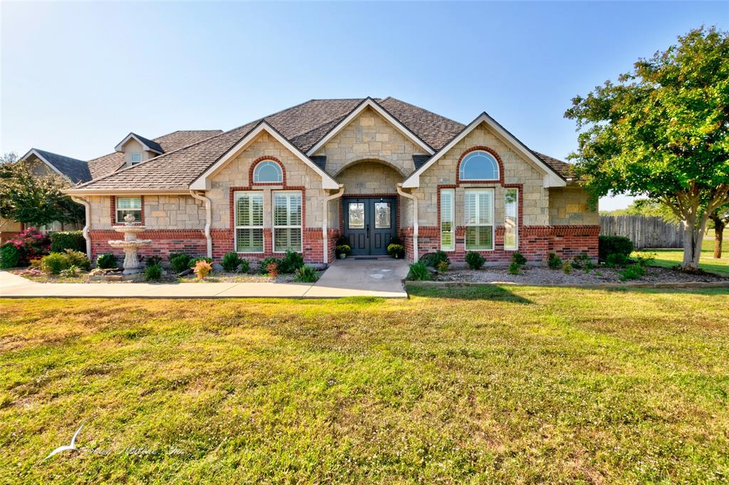 a front view of a house with a yard and swimming pool