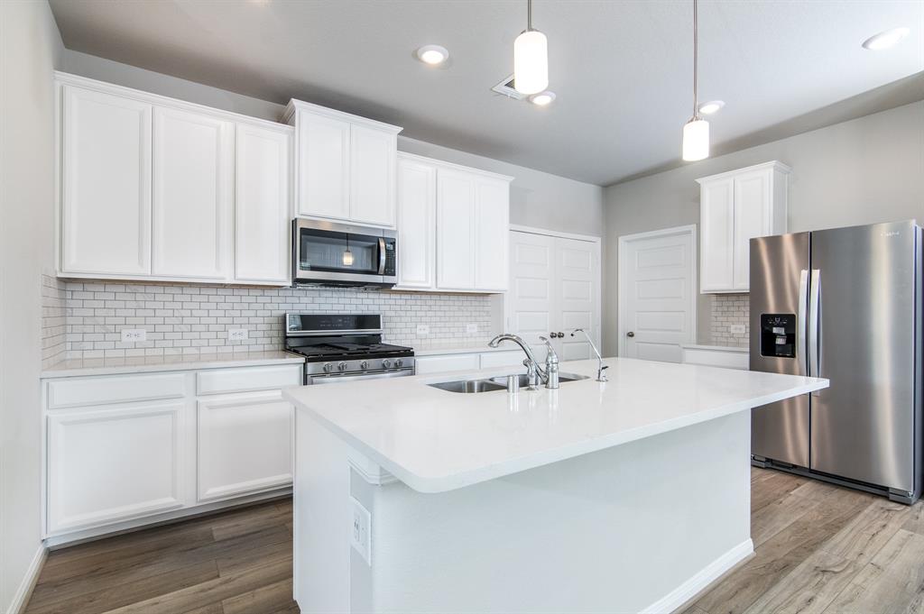 a kitchen with stainless steel appliances a stove a sink a microwave and cabinets