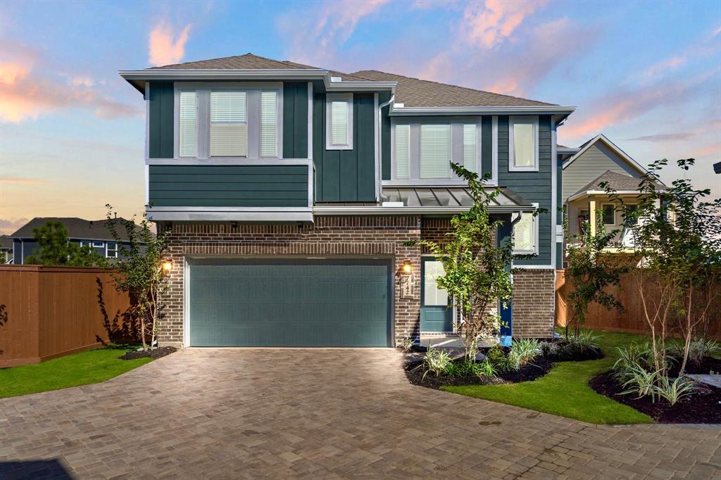 a front view of a house with a garden and garage