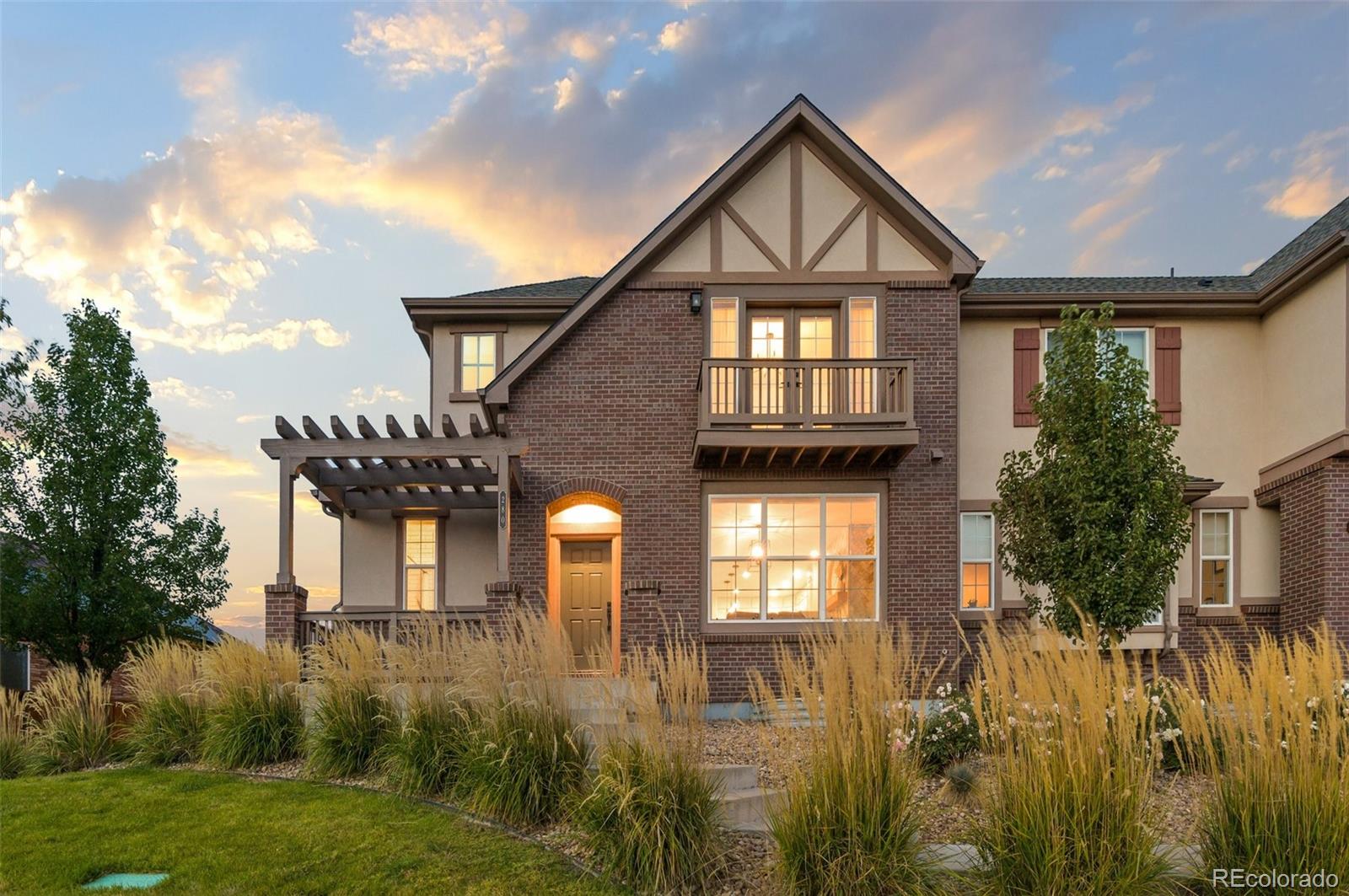 a front view of a house with a yard and lake view