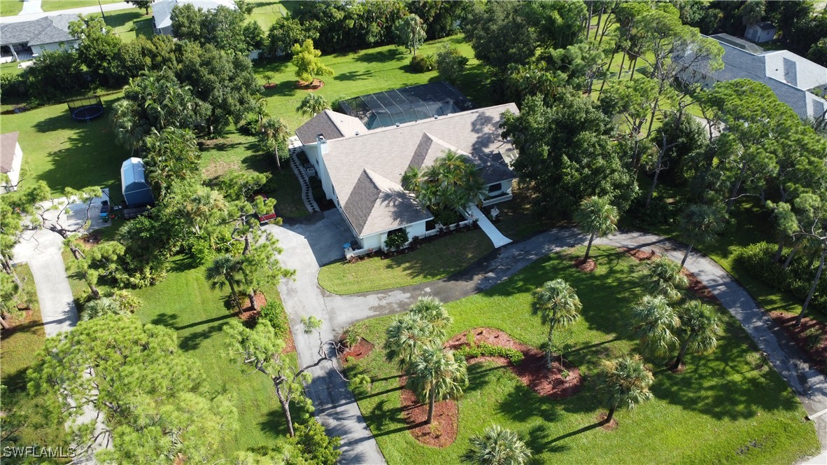 an aerial view of a house with a yard and lake view