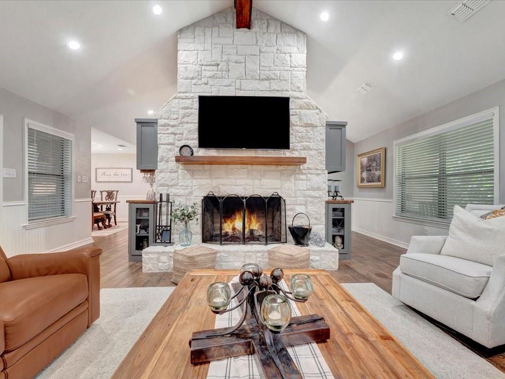 a living room with furniture a fireplace and a flat screen tv