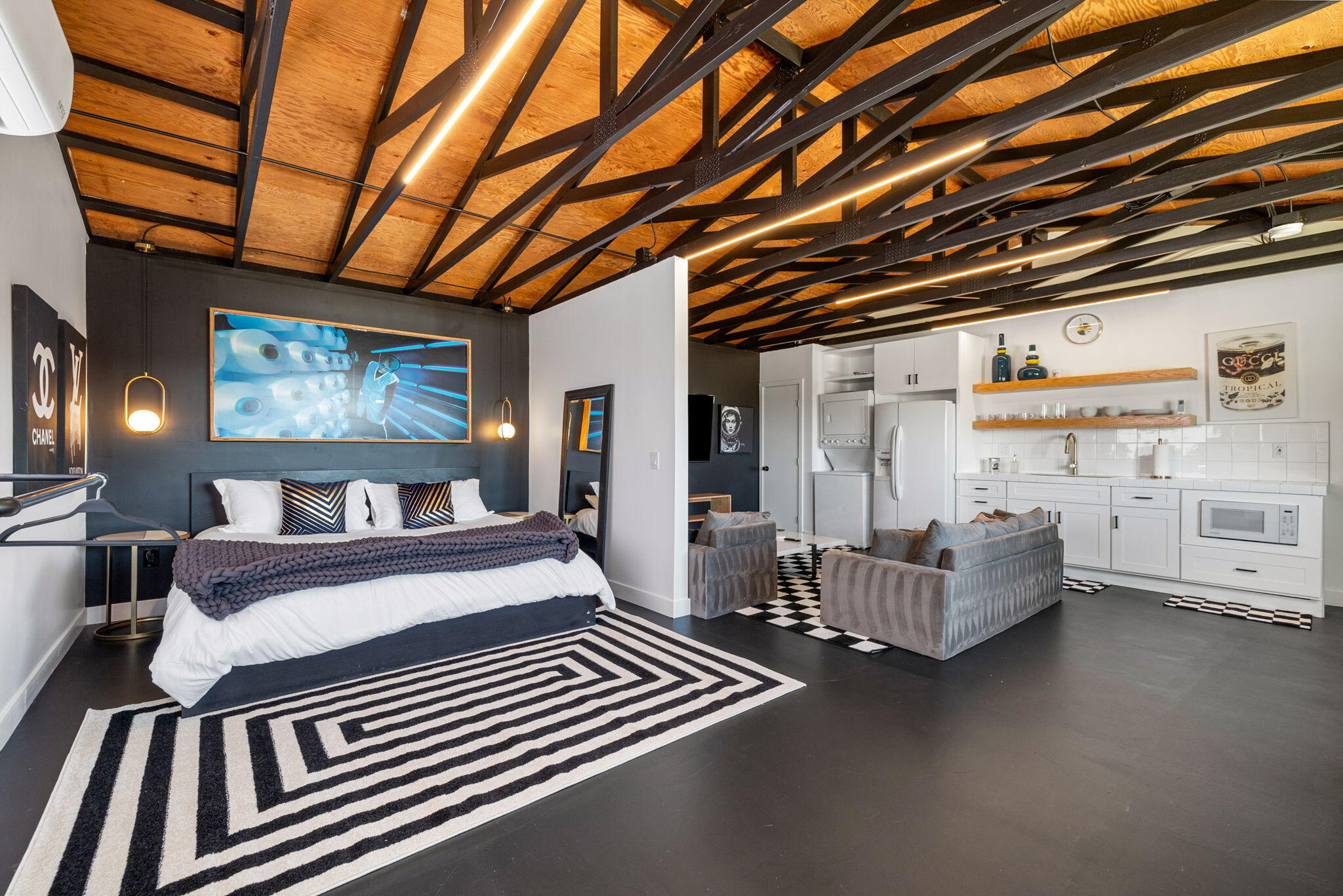 a spacious bedroom with a bed couch chandelier