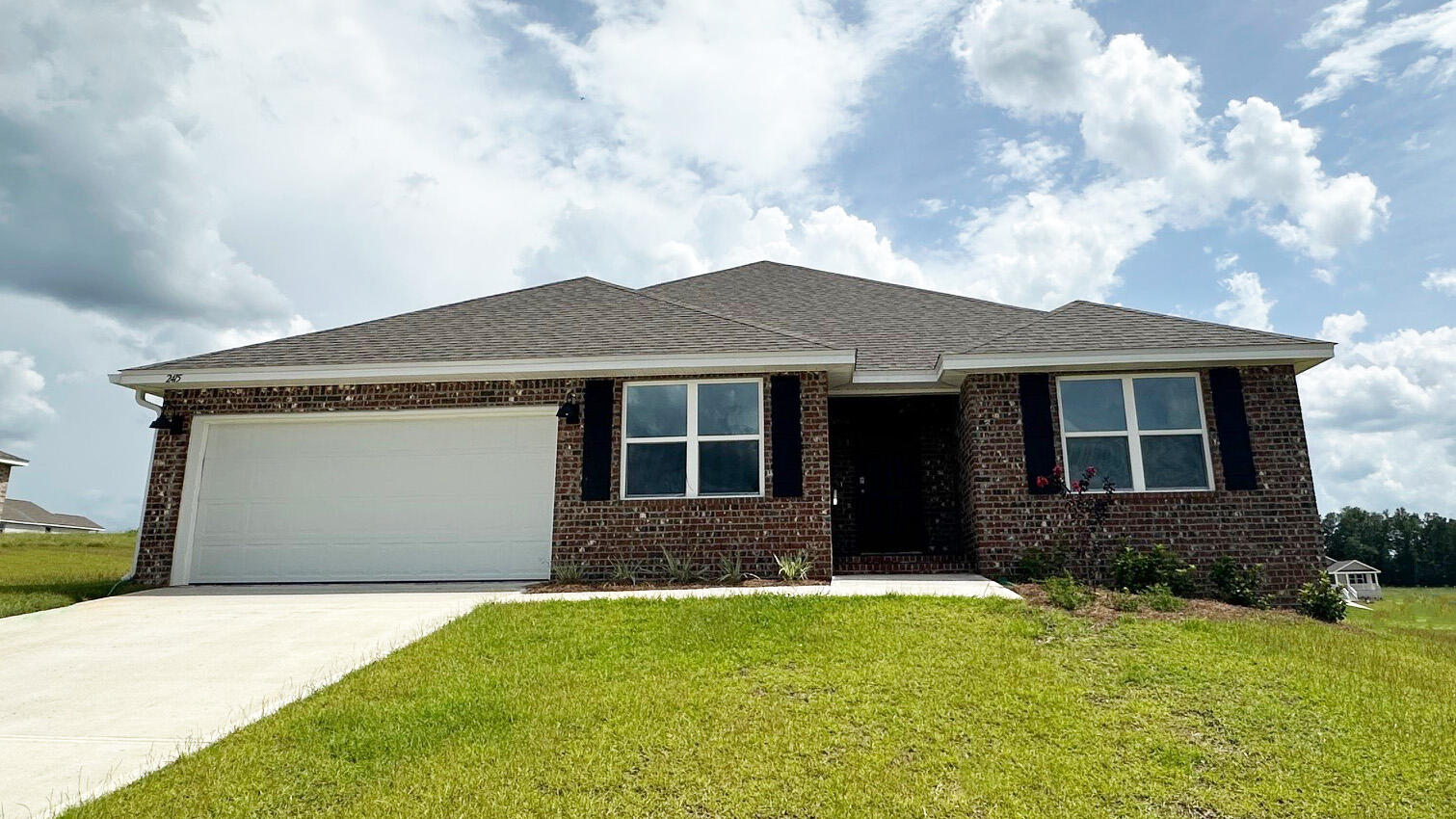 a front view of a house with yard and garage