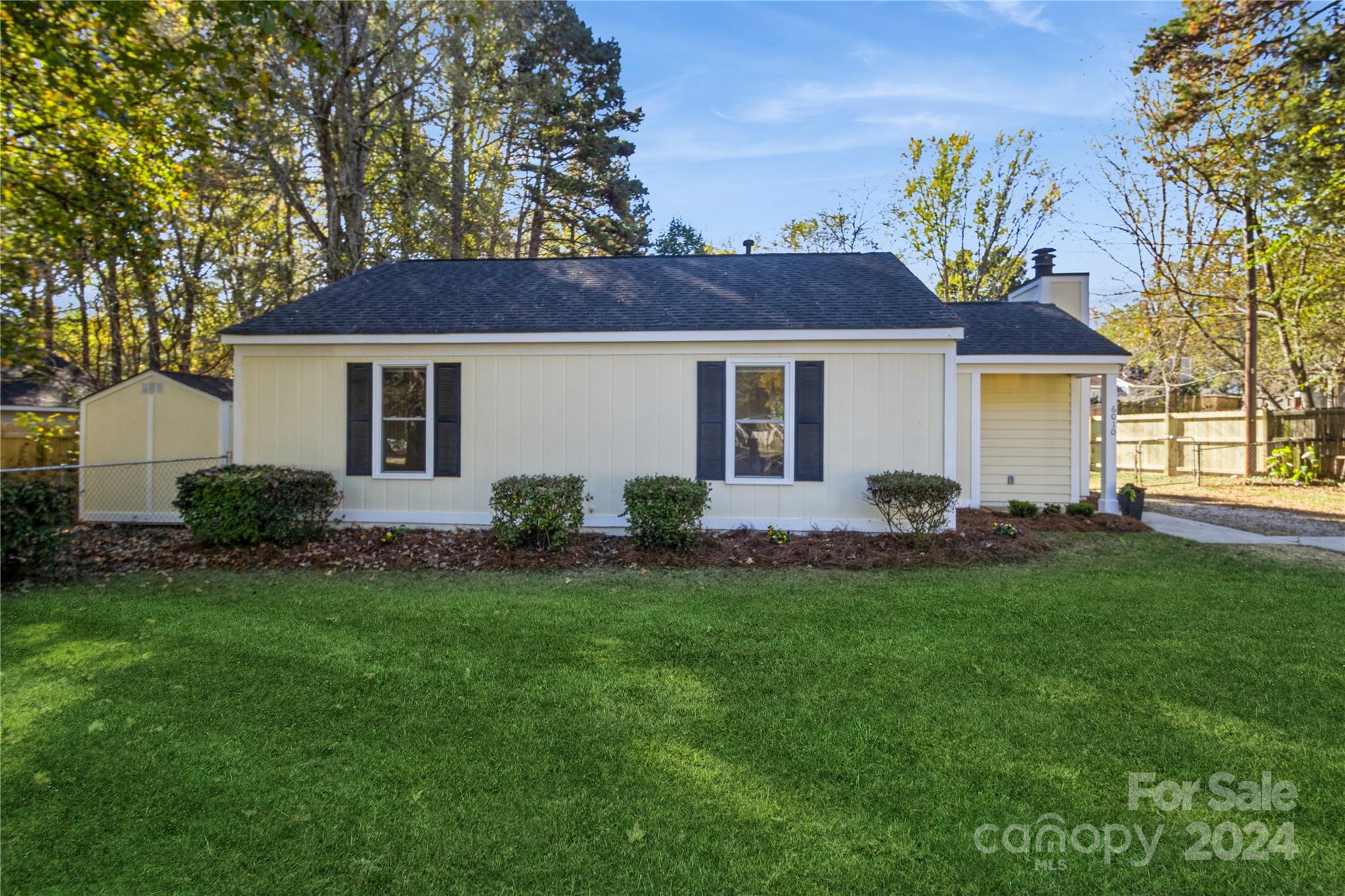 a front view of a house with a garden and yard