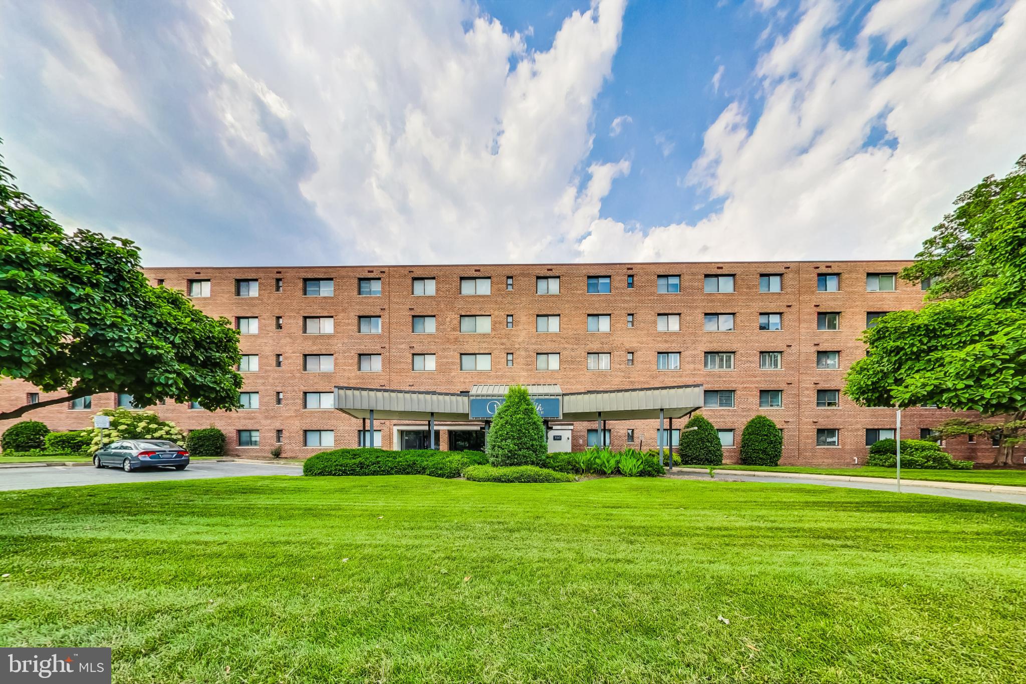 a view of a big building with big yard and large trees