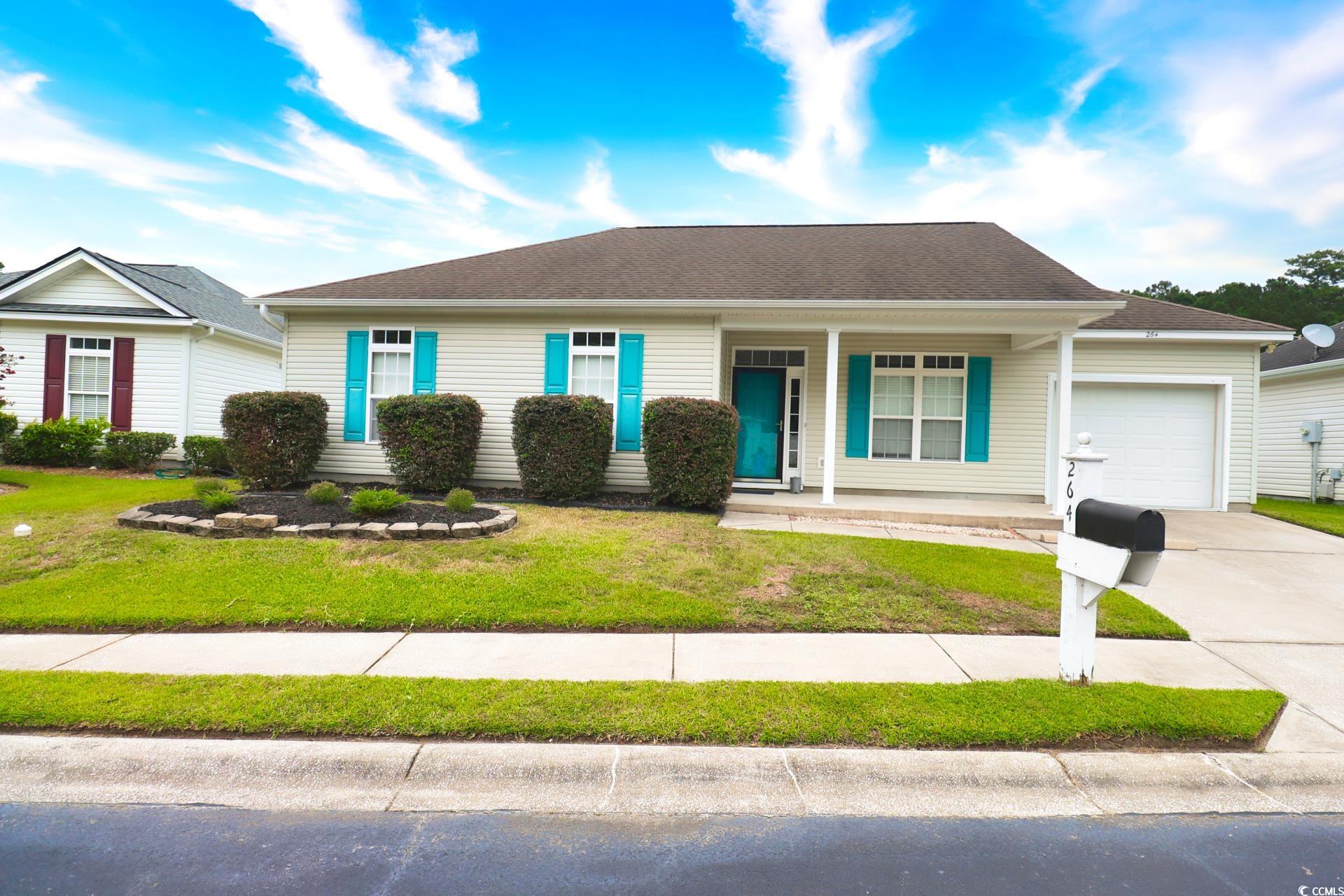 Single story home featuring a front yard, covered