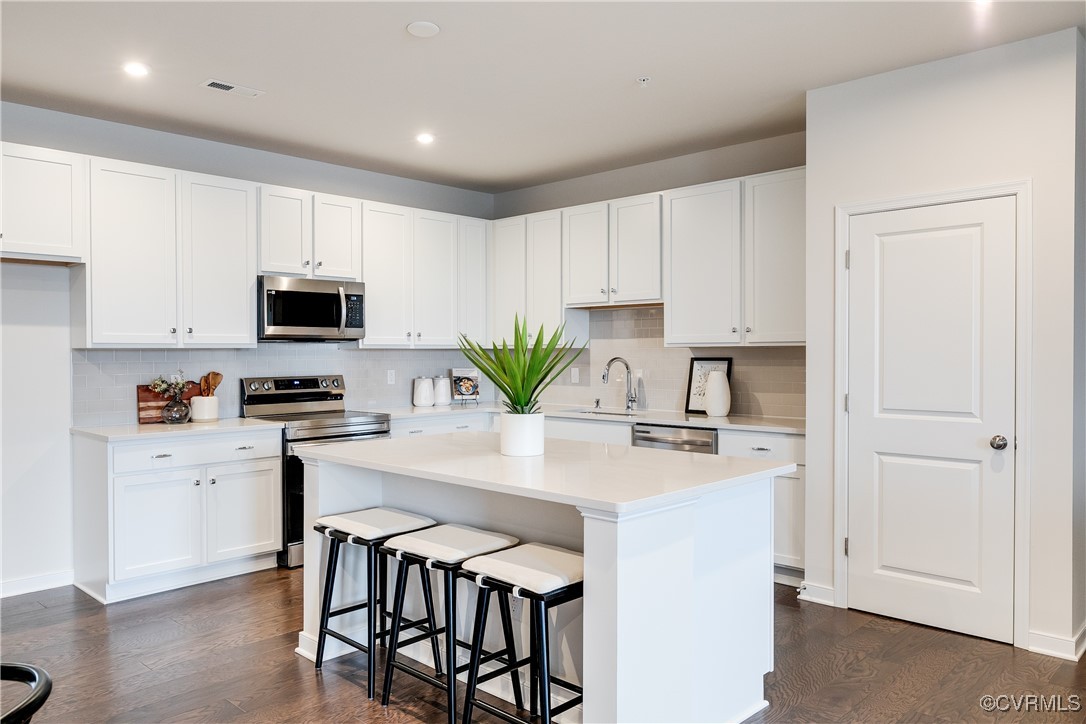 a kitchen with appliances a sink and cabinets