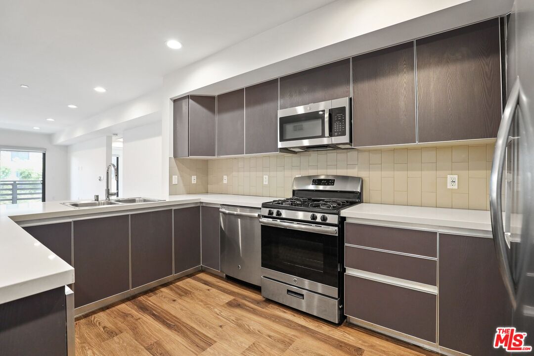 a kitchen with stainless steel appliances granite countertop a stove and a sink