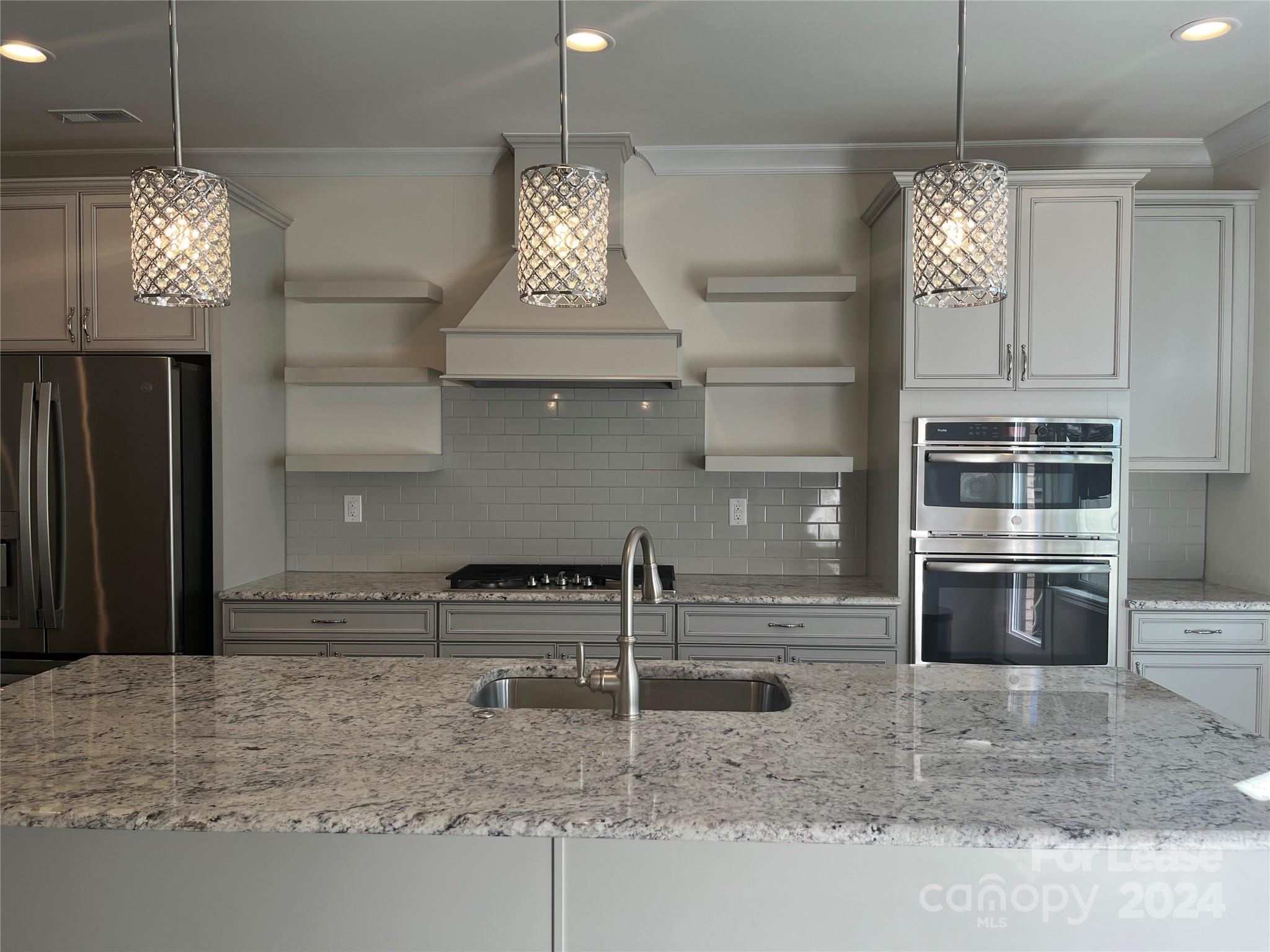 a kitchen with stainless steel appliances granite countertop a sink and refrigerator