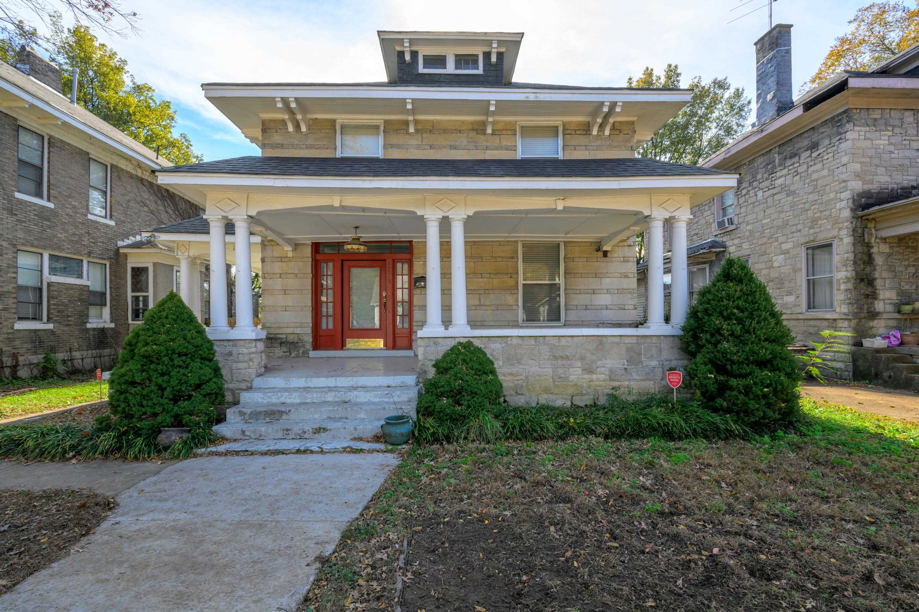 a front view of a house with garden and plants