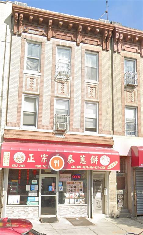 a front view of multi story building with retail shops