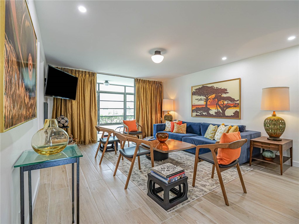 a dining room with furniture a rug and a floor to ceiling window