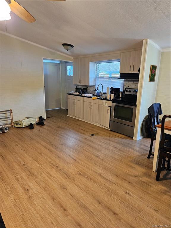 a kitchen with a refrigerator wooden floor and black cabinets