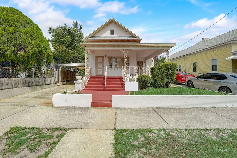 a front view of a house with a yard and potted plants