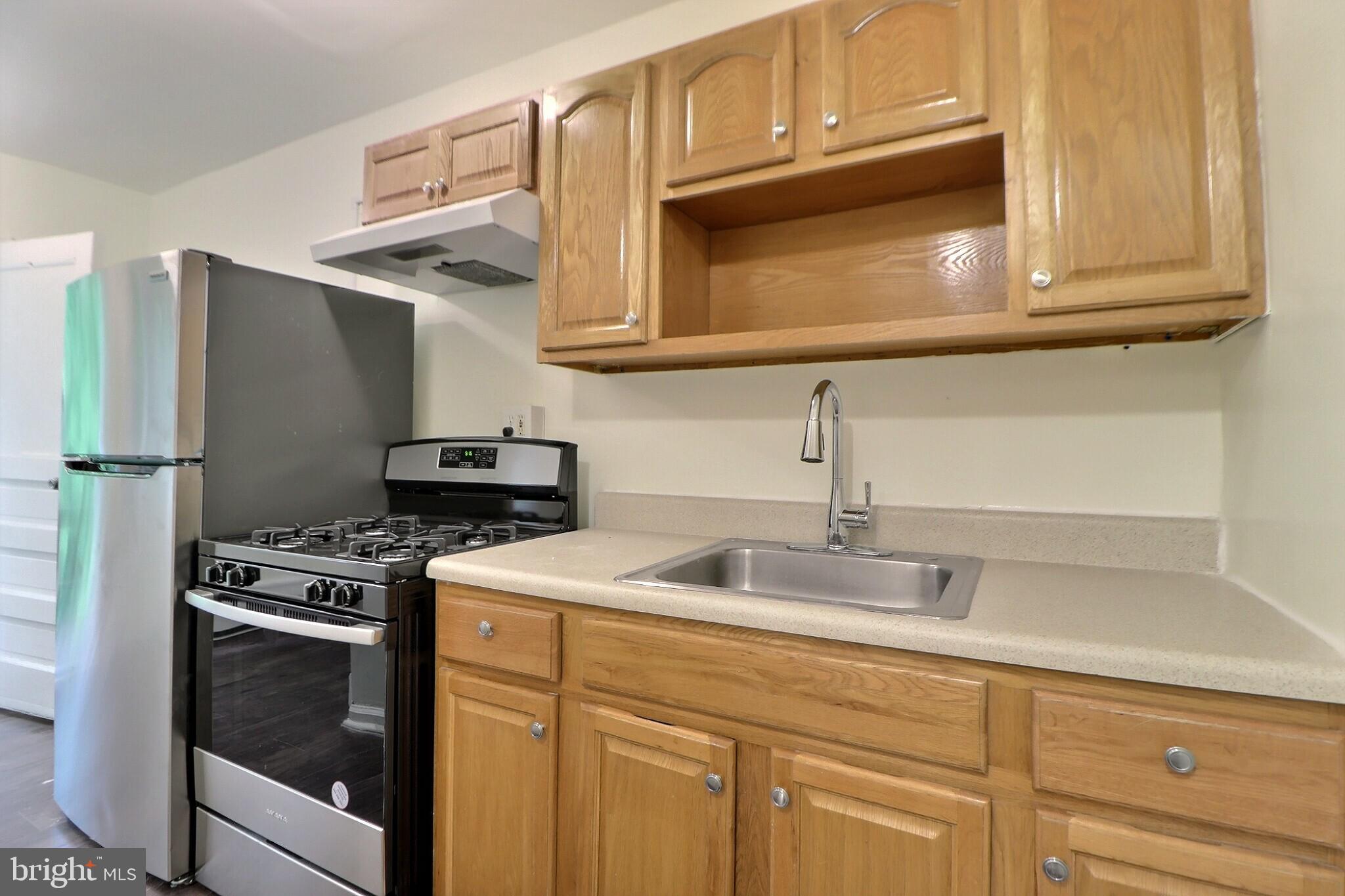 a kitchen with stainless steel appliances granite countertop white cabinets and a stove top oven