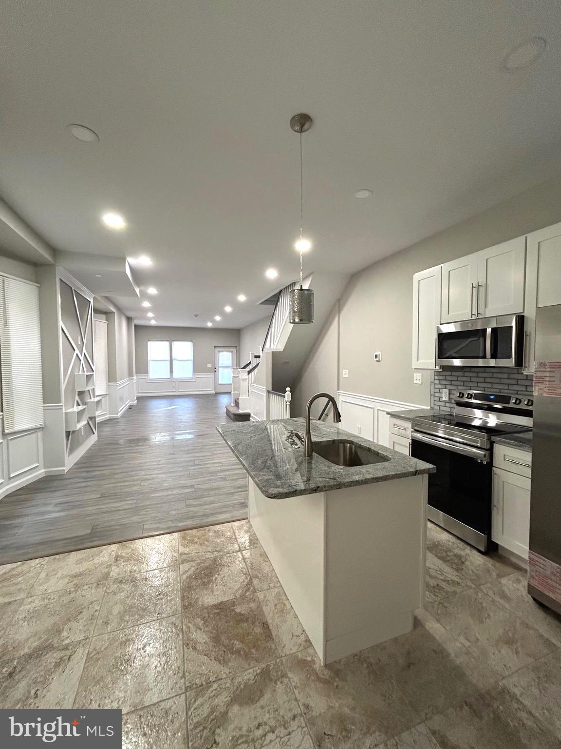 a kitchen with stainless steel appliances granite countertop a sink and a refrigerator