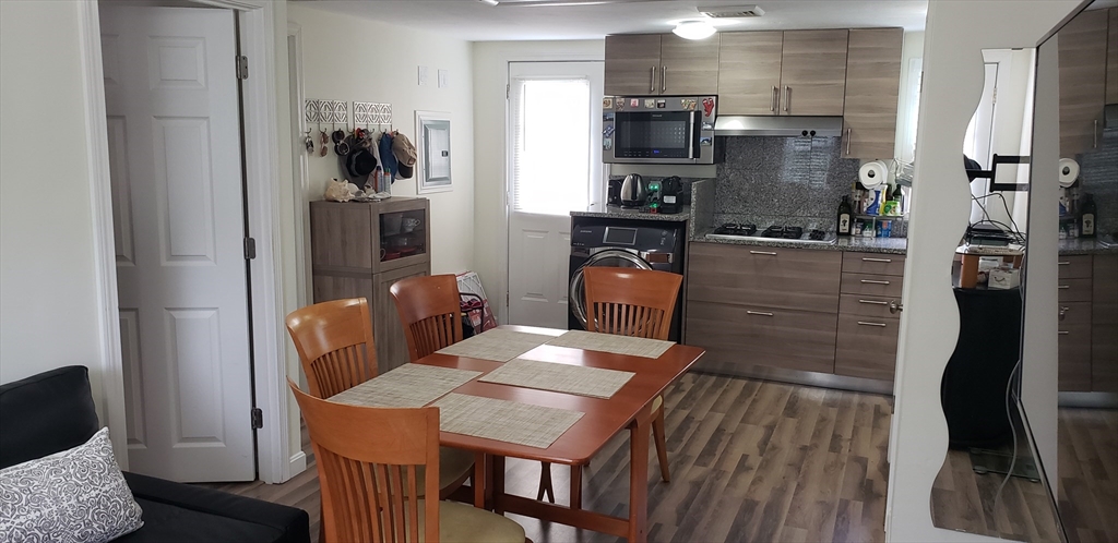 a open kitchen with stainless steel appliances kitchen island granite countertop a refrigerator a stove a sink dishwasher with a dining table and chairs