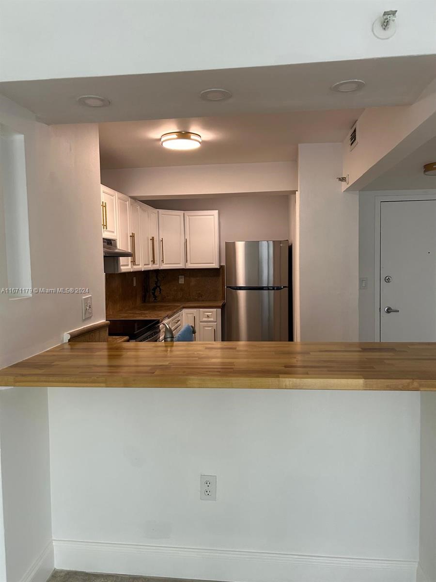 a view of kitchen with refrigerator and window