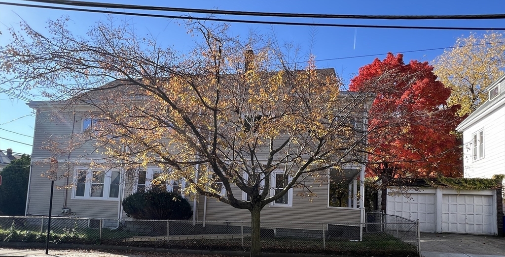 a front view of a house with a tree