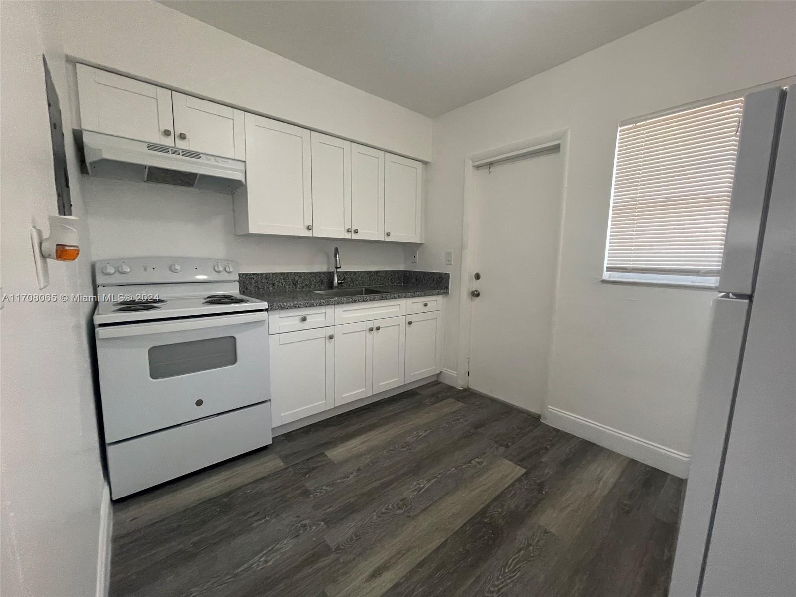 a kitchen with cabinets appliances a sink and a window