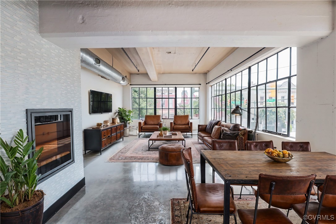 a living room with furniture a flat screen tv and a large window