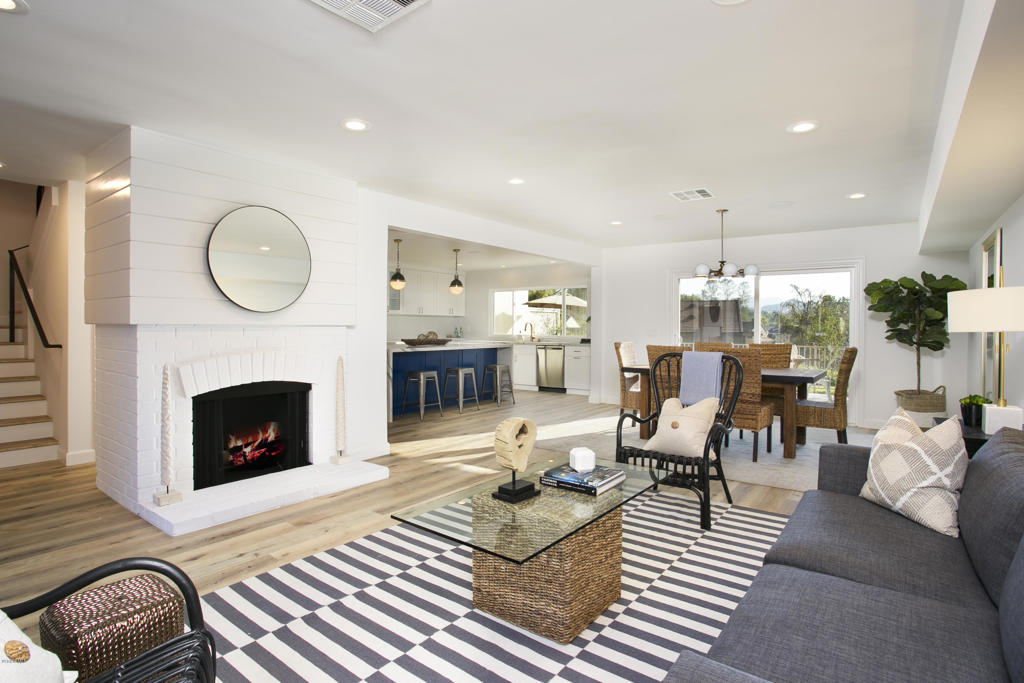 a living room with furniture a fireplace and a floor to ceiling window