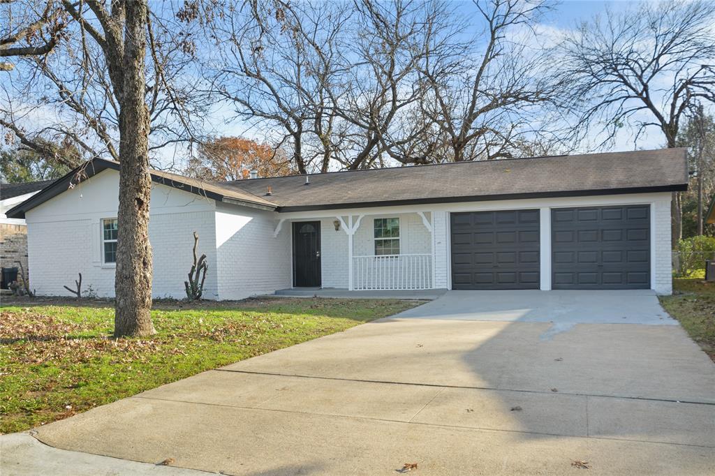 a front view of house with yard and trees in the background