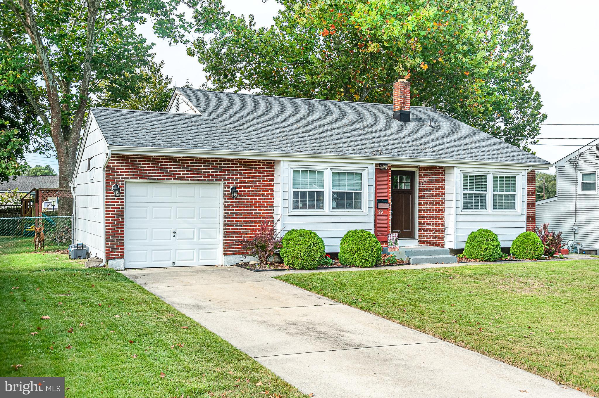 a front view of a house with a yard and plants