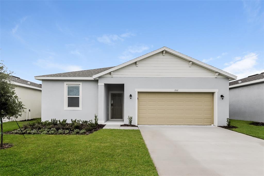 a front view of house with yard and garage