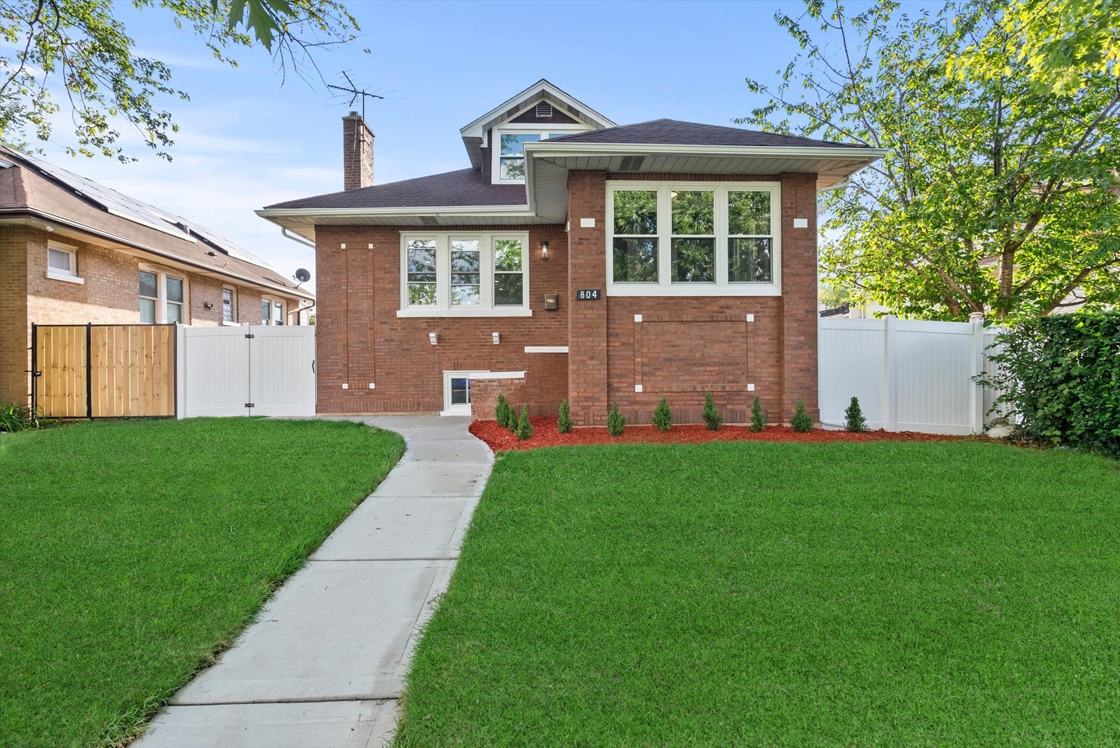 a front view of a house with a garden and yard