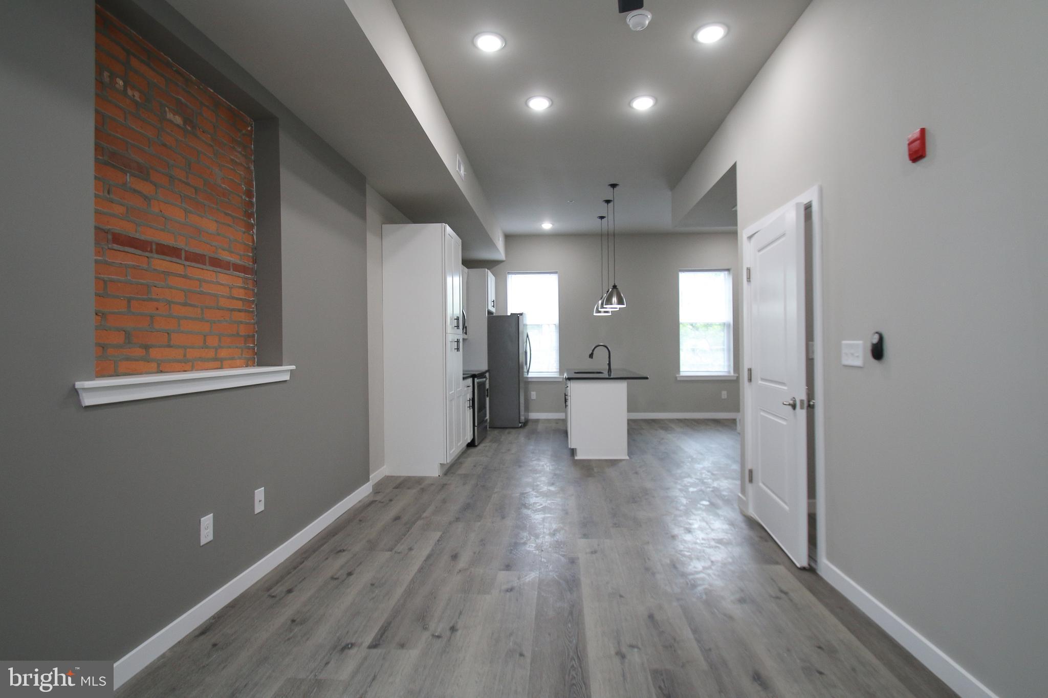 a view of a hallway with wooden floor