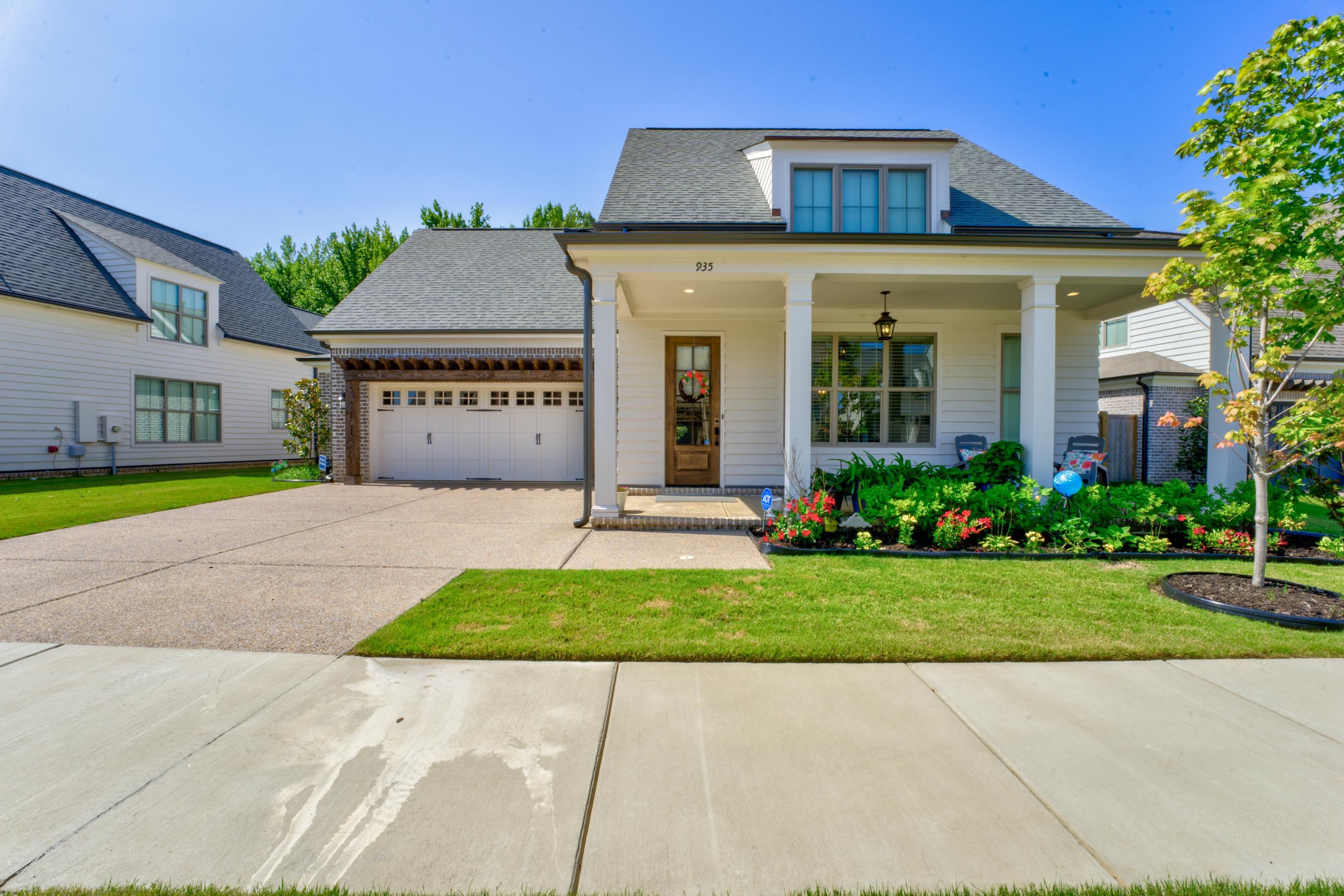 View of front of house with a porch, a front lawn, and a garage