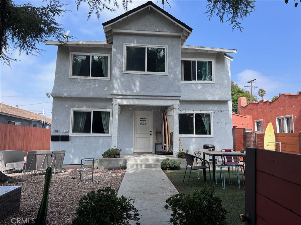 a front view of a house with a yard and outdoor seating