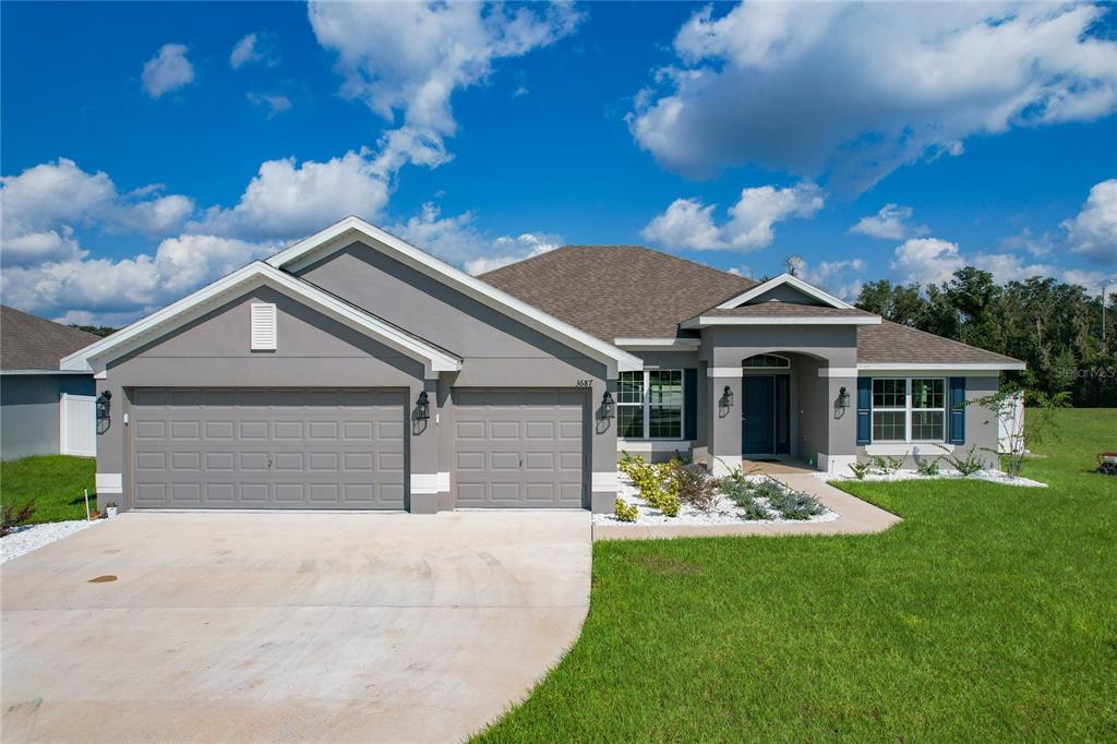 a front view of a house with a yard and garage