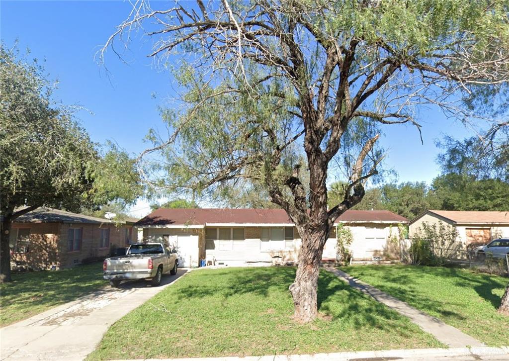 a view of a yard in front of a house with large tree