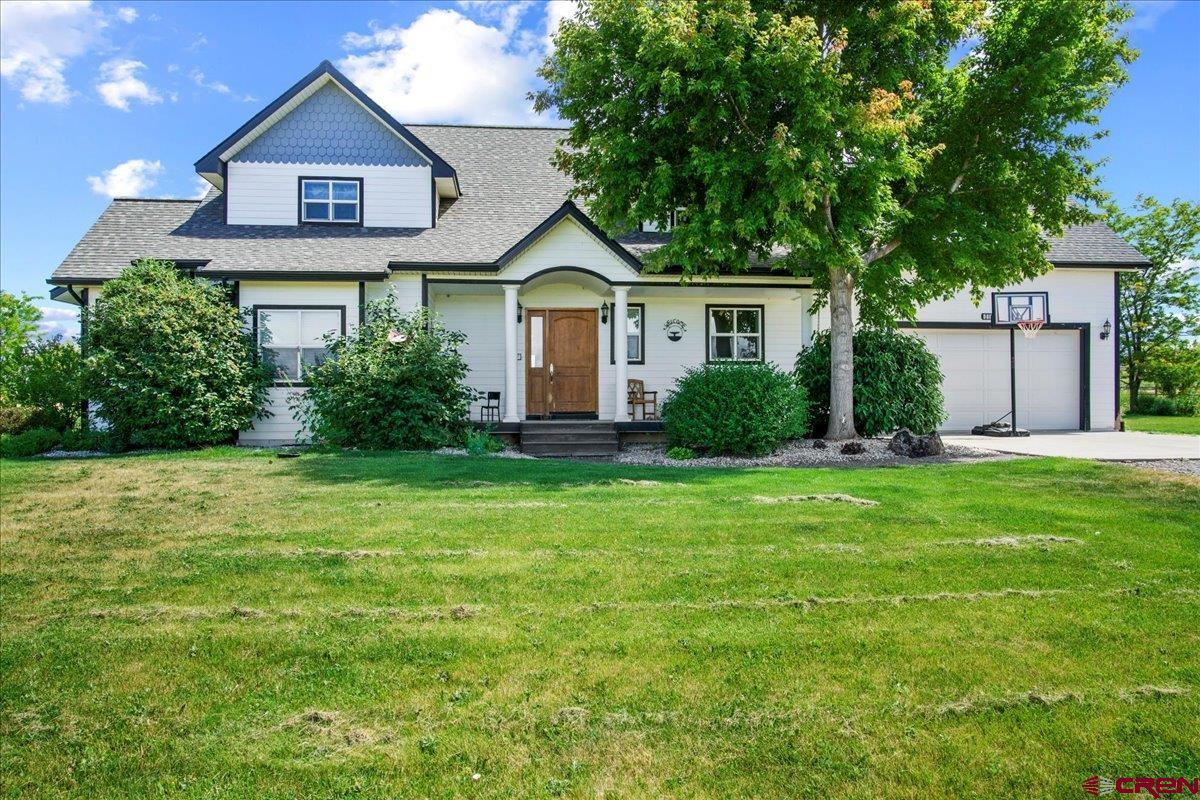 a front view of a house with a yard and trees